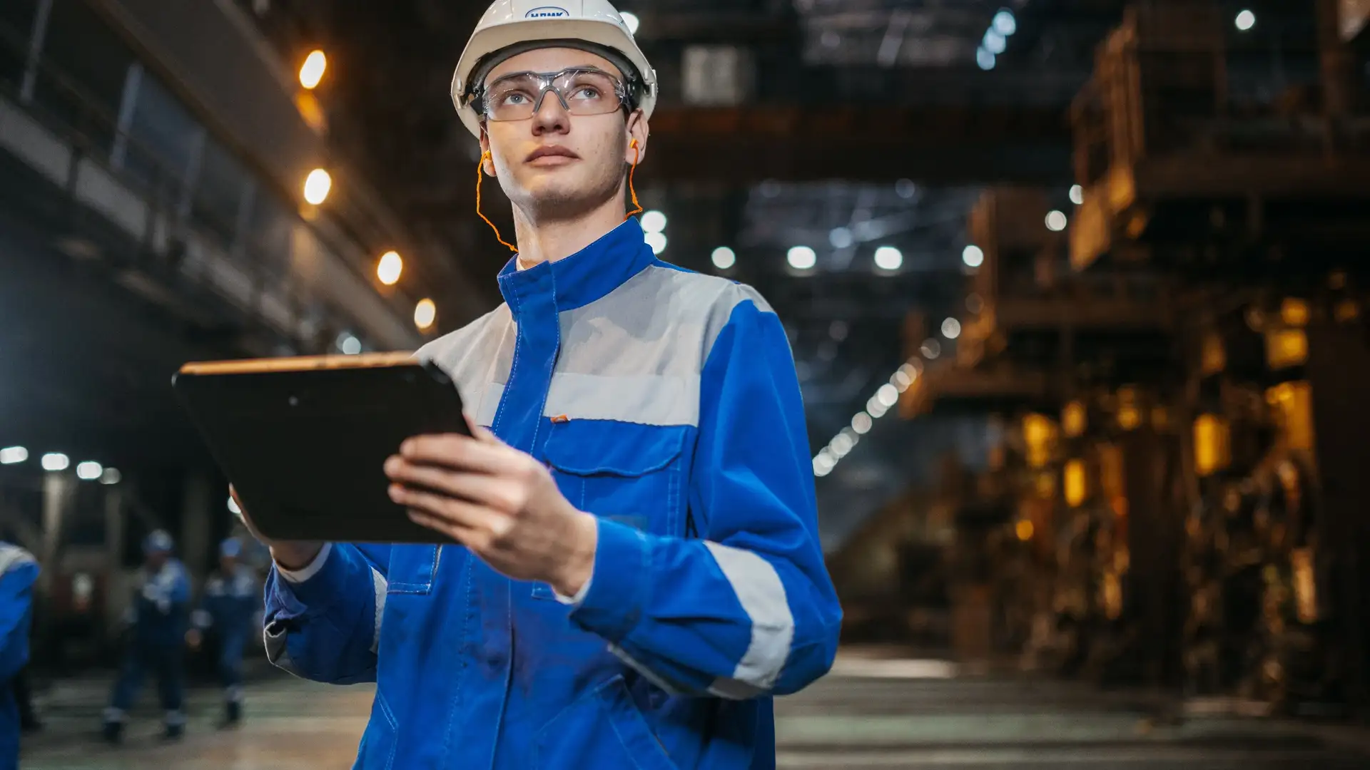 Engineer with a tablet in a large industrial plant